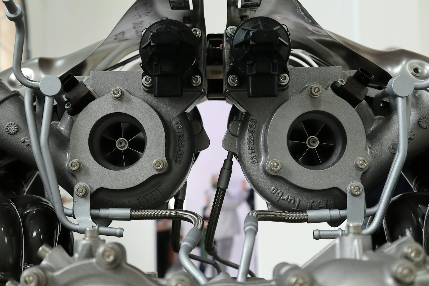 Dwa metalowe turbosprężarki typu twin-scroll ze skomplikowanymi przewodami i połączeniami.